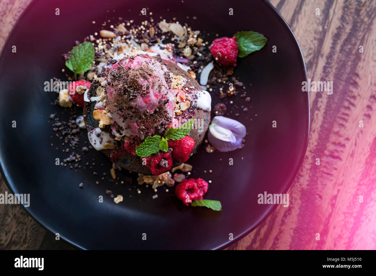 Decorate dessert rosa con lampone e foglie di menta Foto Stock