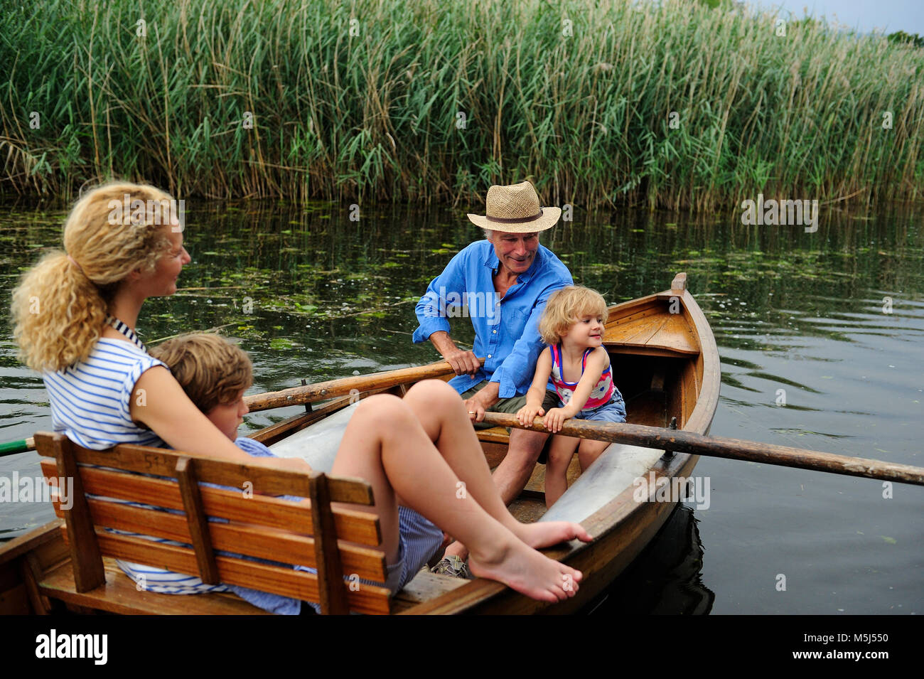 Famiglia in barca a remi sul lago Foto Stock