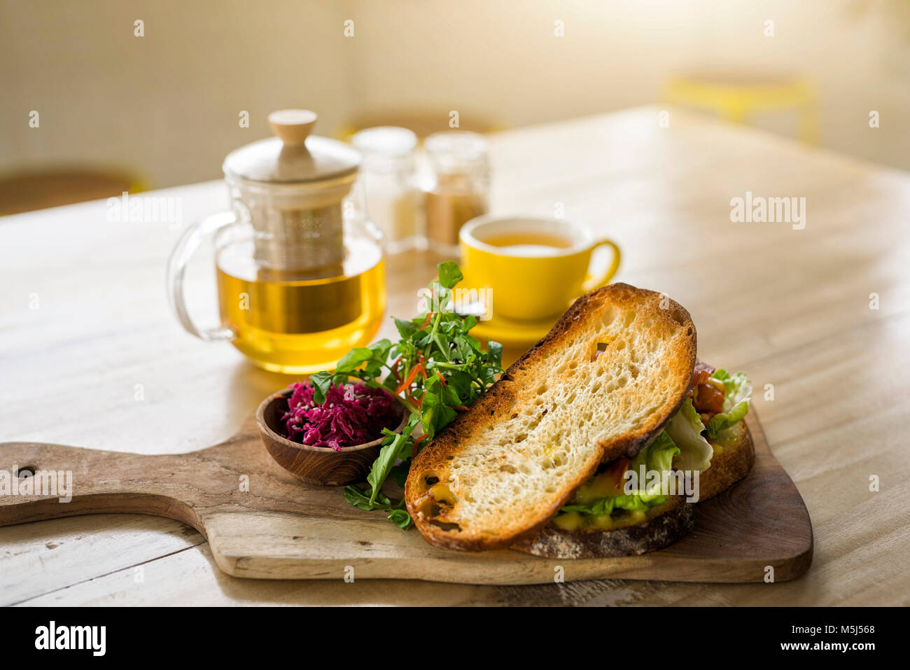 Crostini di pane con insalata verde e barbabietola sul piatto di legno e il tè verde in cafe Foto Stock