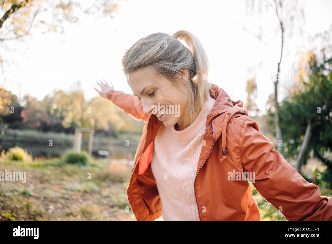 Ritratto di felice giovane donna bilanciamento in parco autunnali Foto Stock