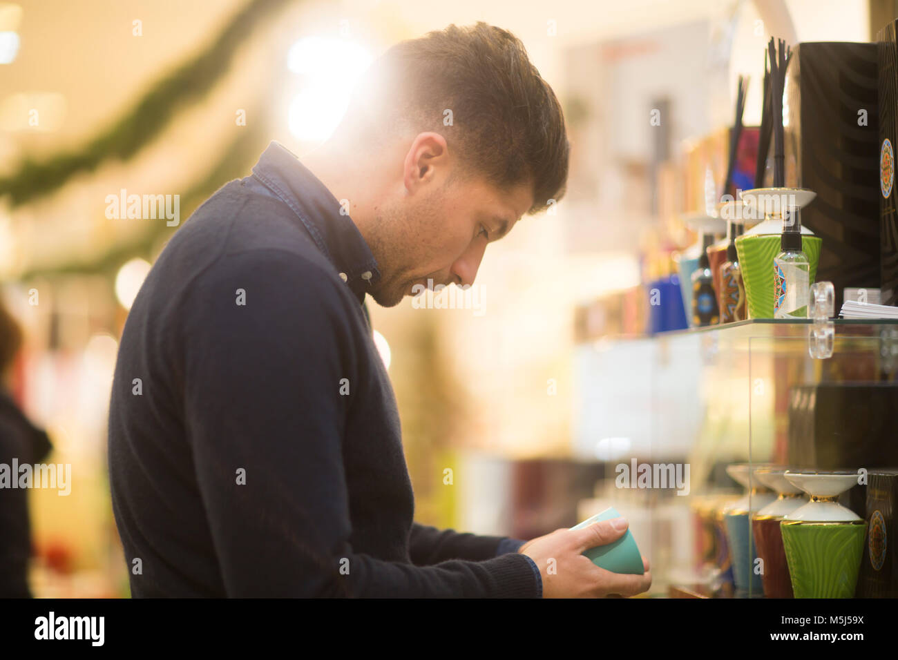 Incerta l'uomo cerca di regalo di Natale in un negozio Foto Stock