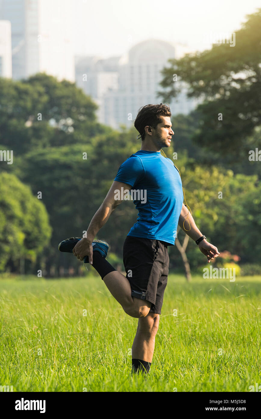 Runner in fase di riscaldamento nel parco urbano Foto Stock