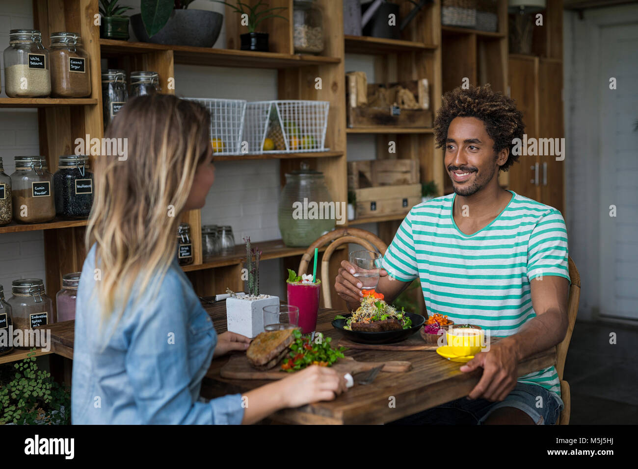 Coppia sorridente gustando un pasto insieme nel ristorante accogliente Foto Stock