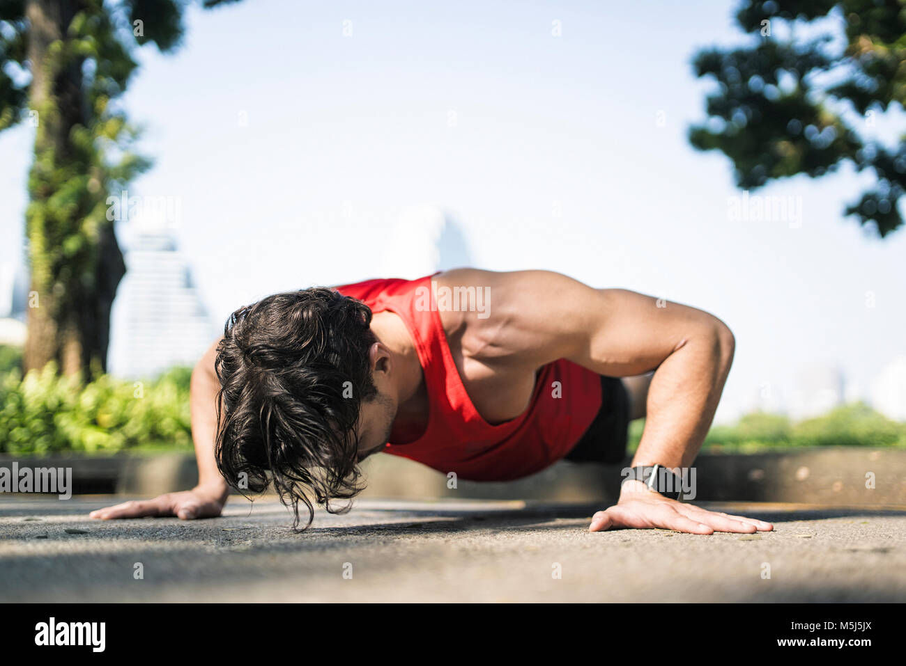 Atleta facendo push-up nel parco urbano Foto Stock
