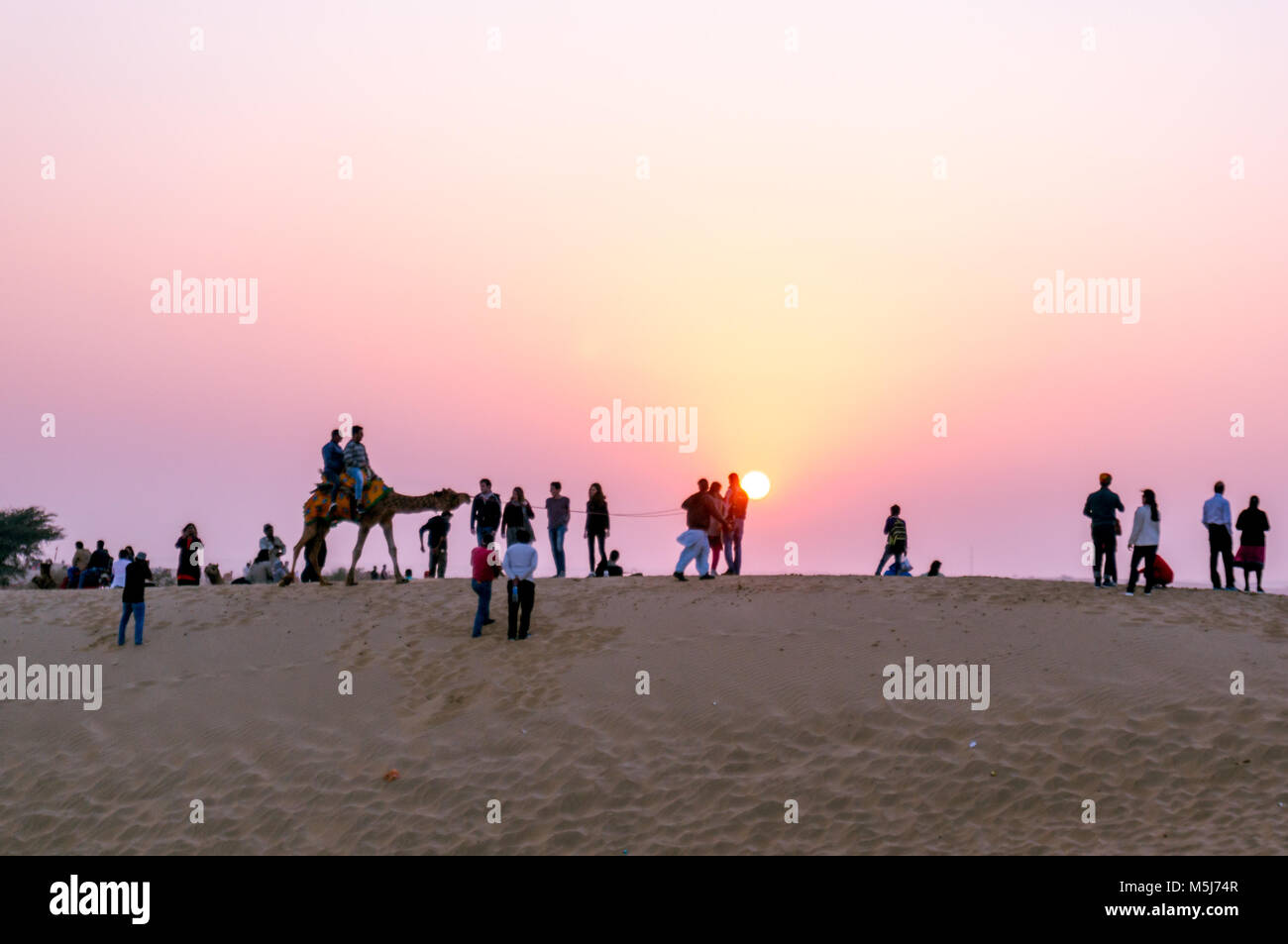 Bikaner, India - 29 DIC 2017: Silhouette di persone e di cammelli. Colpo contro l'impostazione di questo splendido paesaggio mette in mostra il motivo per somma essendo una destinazione turistica Foto Stock