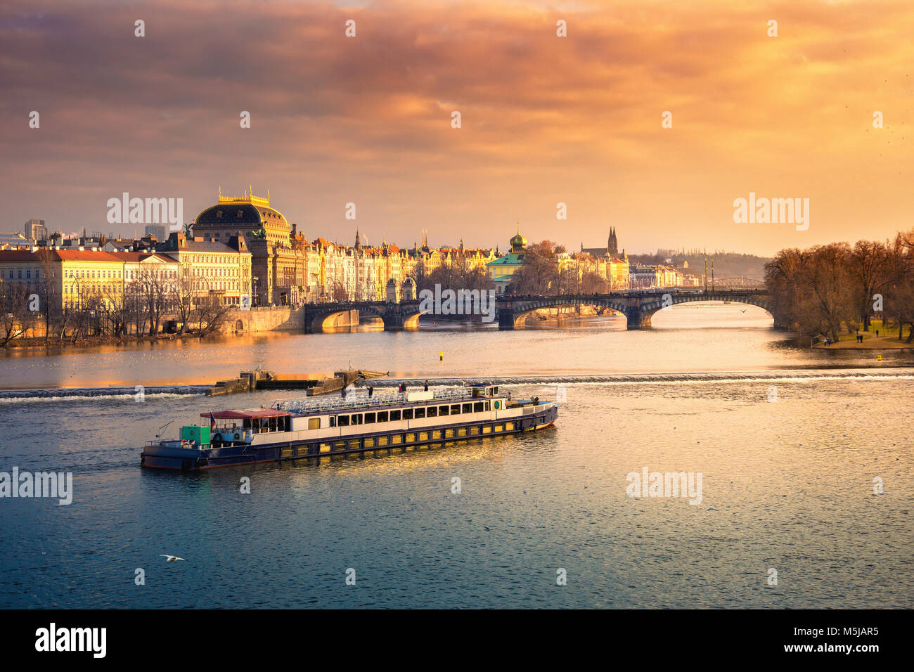 Famoso teatro nazionale e la legione bridge con la barca al tramonto, Praga, Repubblica Ceca Foto Stock