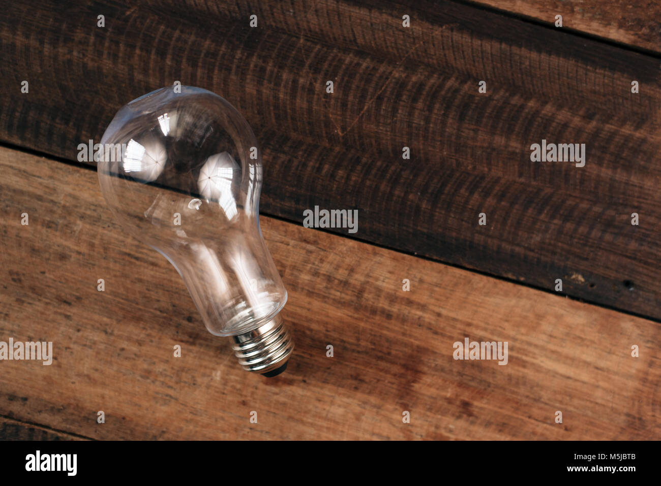 Lampadina della luce su una tavola di legno. idea e il concetto di risparmio energetico Foto Stock