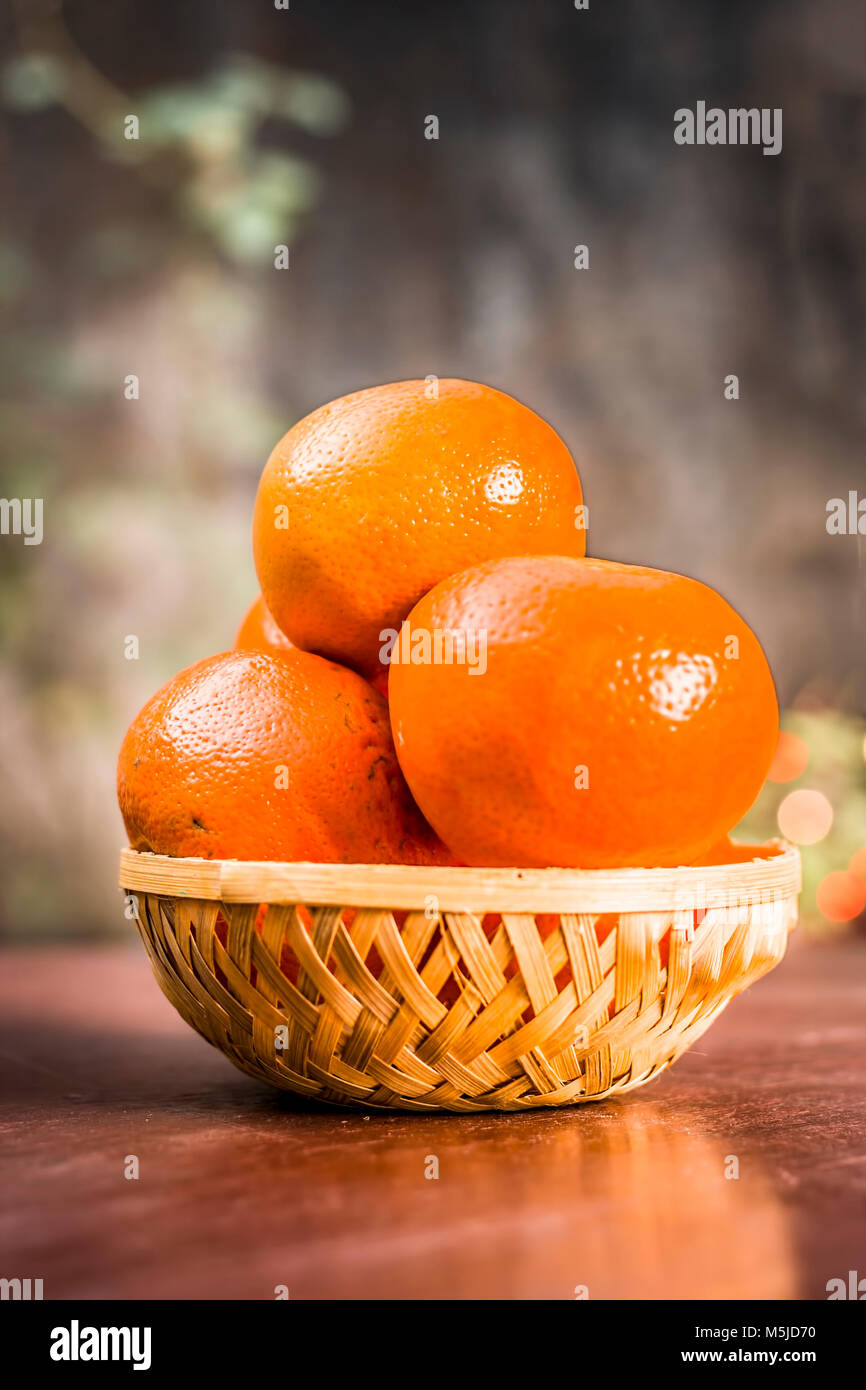 Close up fresche arance mature,Citrus aurantium in una piastra su una superficie di legno. Foto Stock