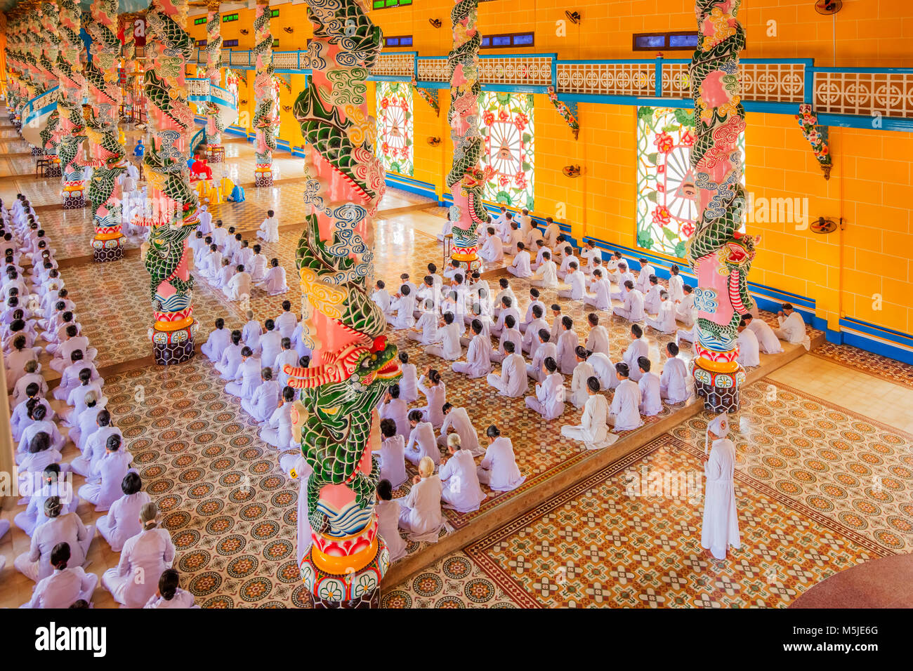 All'interno di Cao Dai Santa Sede tempio, provincia di Tay Ninh, Vietnam e meditando seguaci di Cao Dai religione Foto Stock