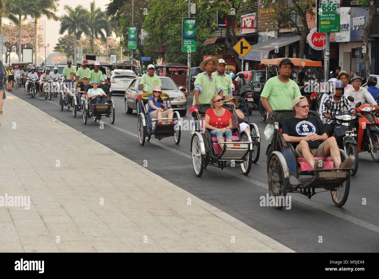 Ecoturismo, i turisti viaggiano in ciclos/risciò in bicicletta lungo il Sisowath Quay Boulevard sul lungofiume. Phnom Penh, Cambogia. Crediti: Kraig Lieb Foto Stock