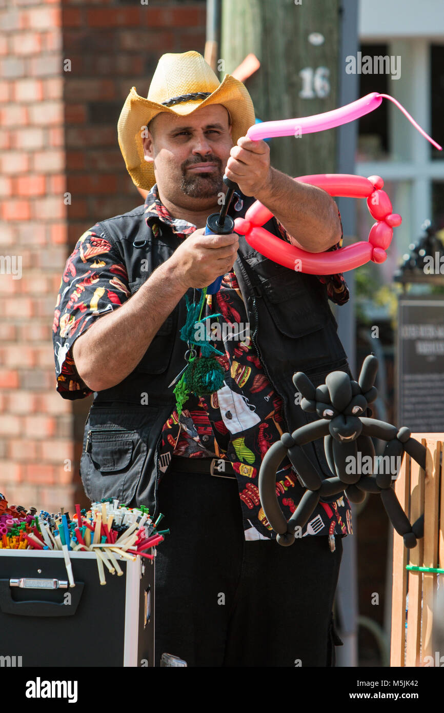 Un uomo che utilizza una pompa aria per soffiare su un palloncino come egli rende gli animali a palloncino in The scarecrow Harvest Festival di Alpharetta, GA il 30 settembre 2017. Foto Stock