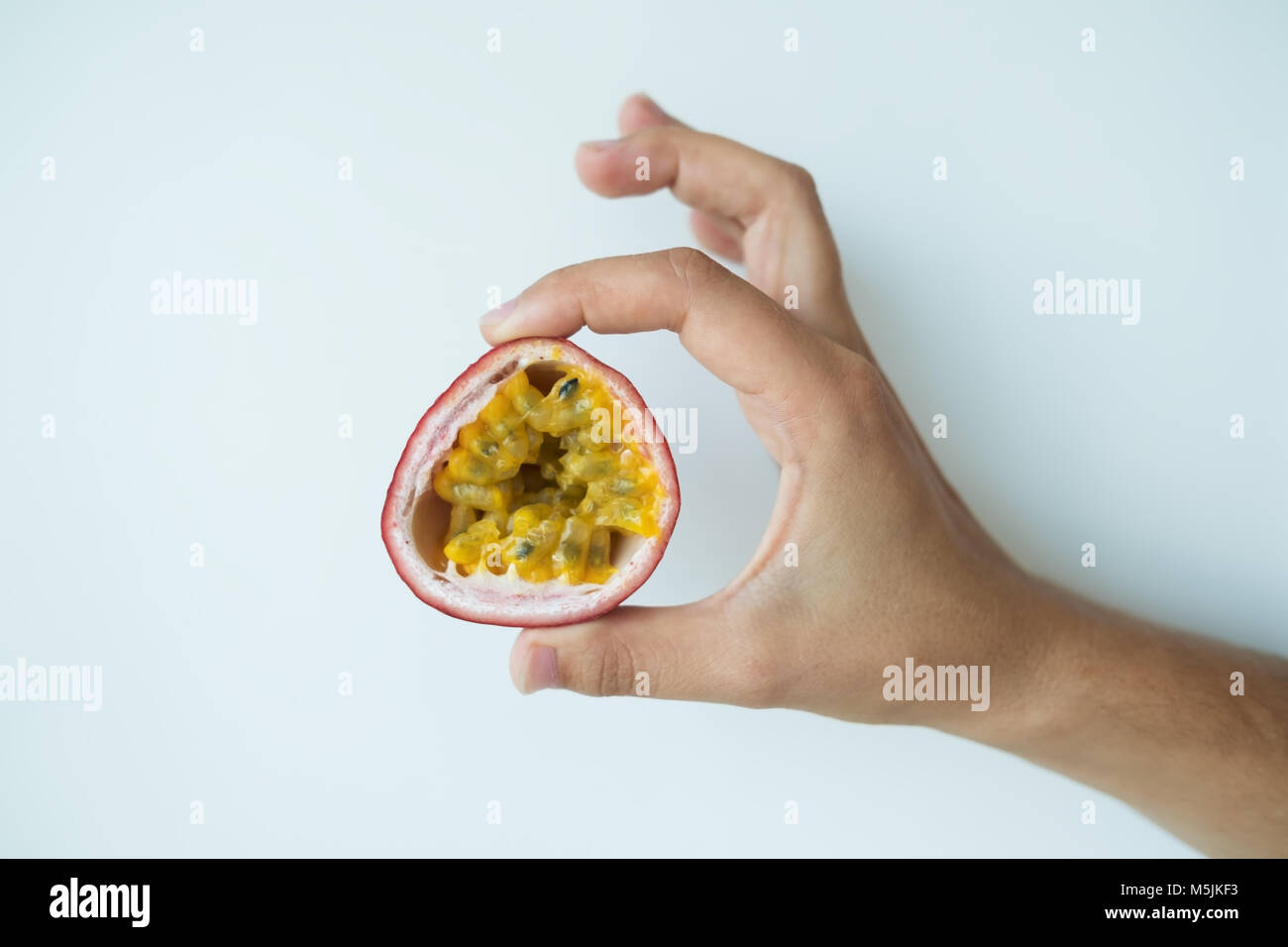 Mano di donna caucasica holding succoso frutto della passione Foto Stock