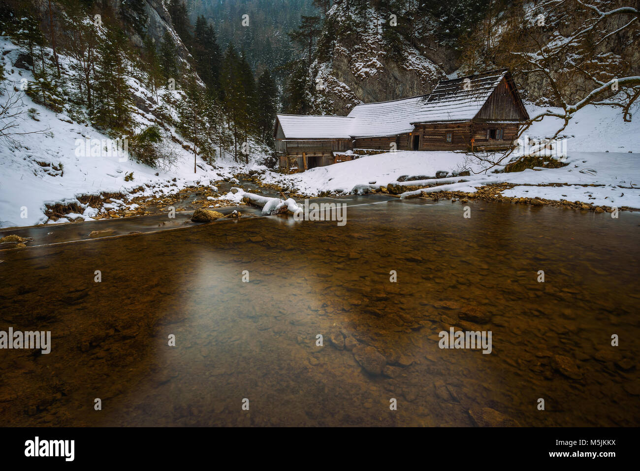 In legno antico mulino ad acqua in inverno Foto Stock