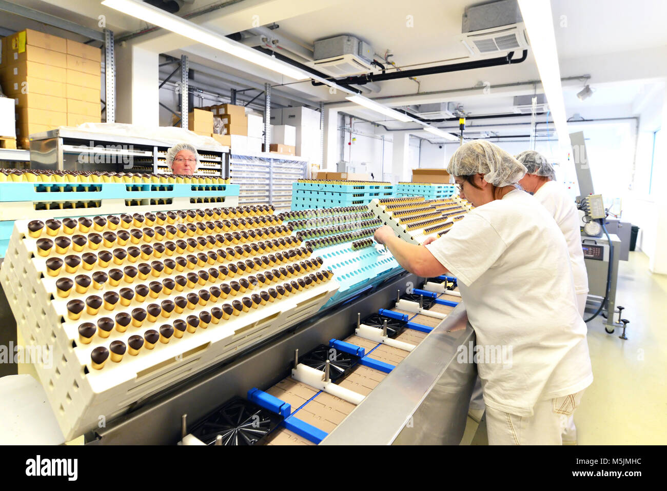 Produzione di praline in una fabbrica per l'industria alimentare - le donne che lavorano sulla linea di assemblaggio Foto Stock