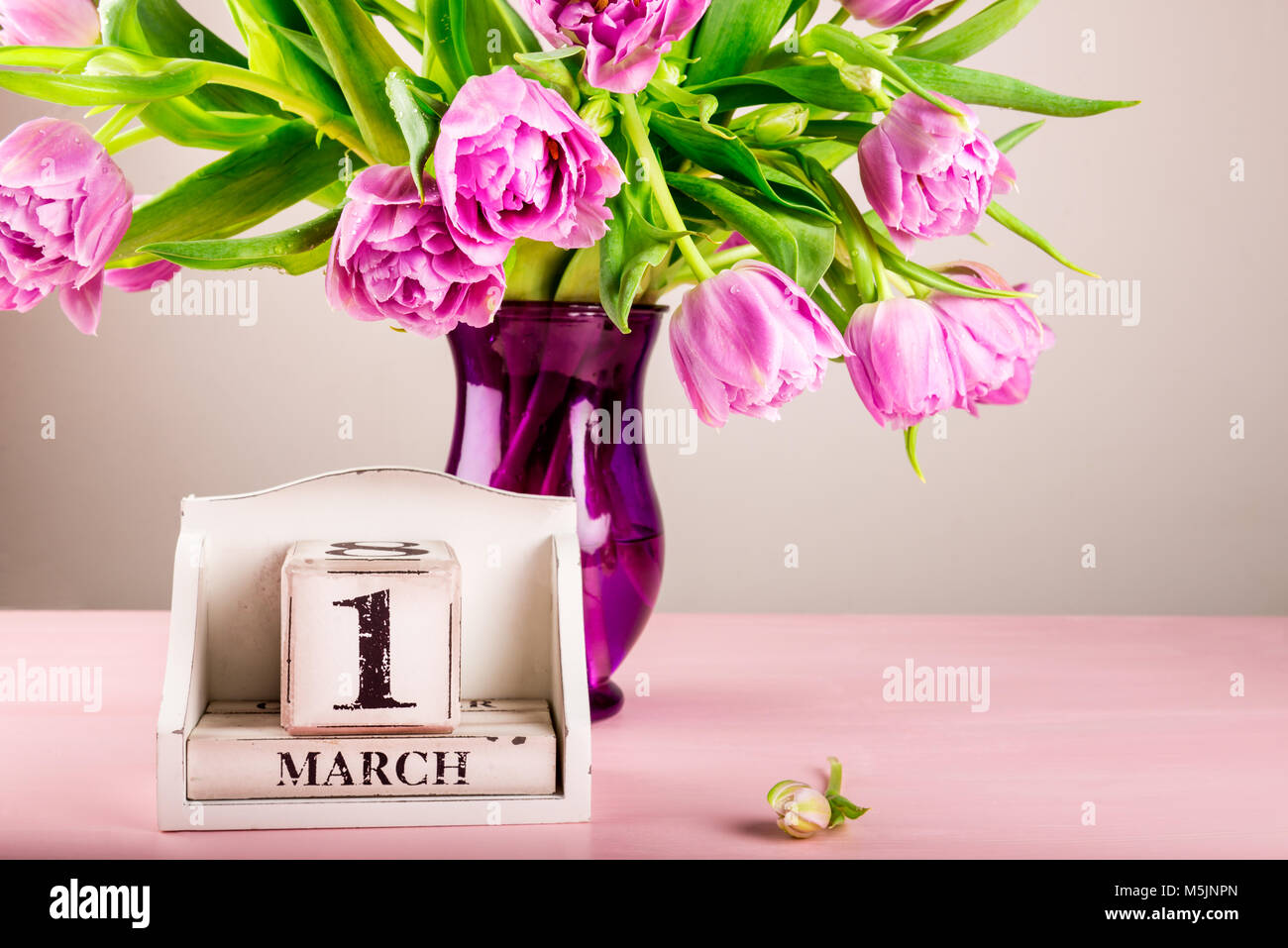 Blocco di legno con data, 1 marzo, il primo giorno di primavera calendare in molti paesi, i tulipani nelle vicinanze Foto Stock