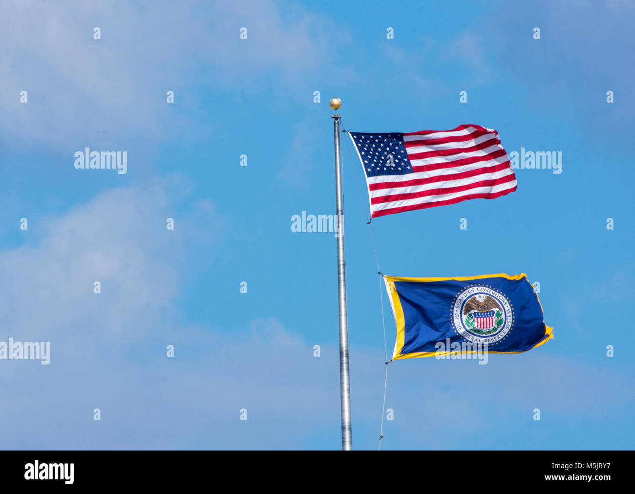 Flag of the Federal Reserve flies beneath the United States flag at the Federal Reserve headquarters in Washington DC. Foto Stock