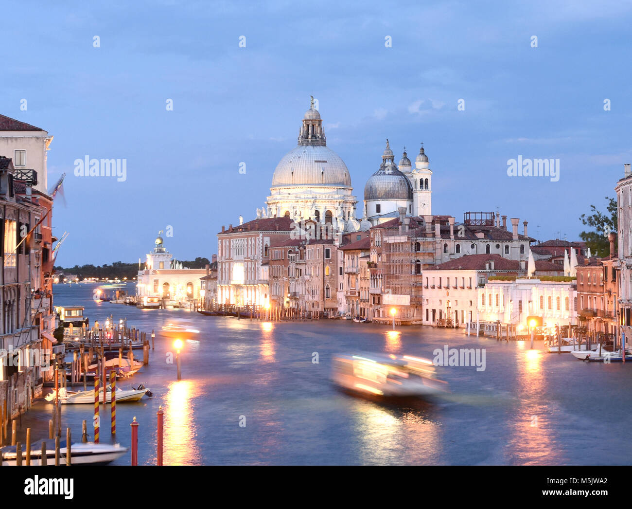Paesaggio urbano di Venezia di notte con il Canal Grande e la Basilica di Santa Maria della Salute, Italia. Foto Stock