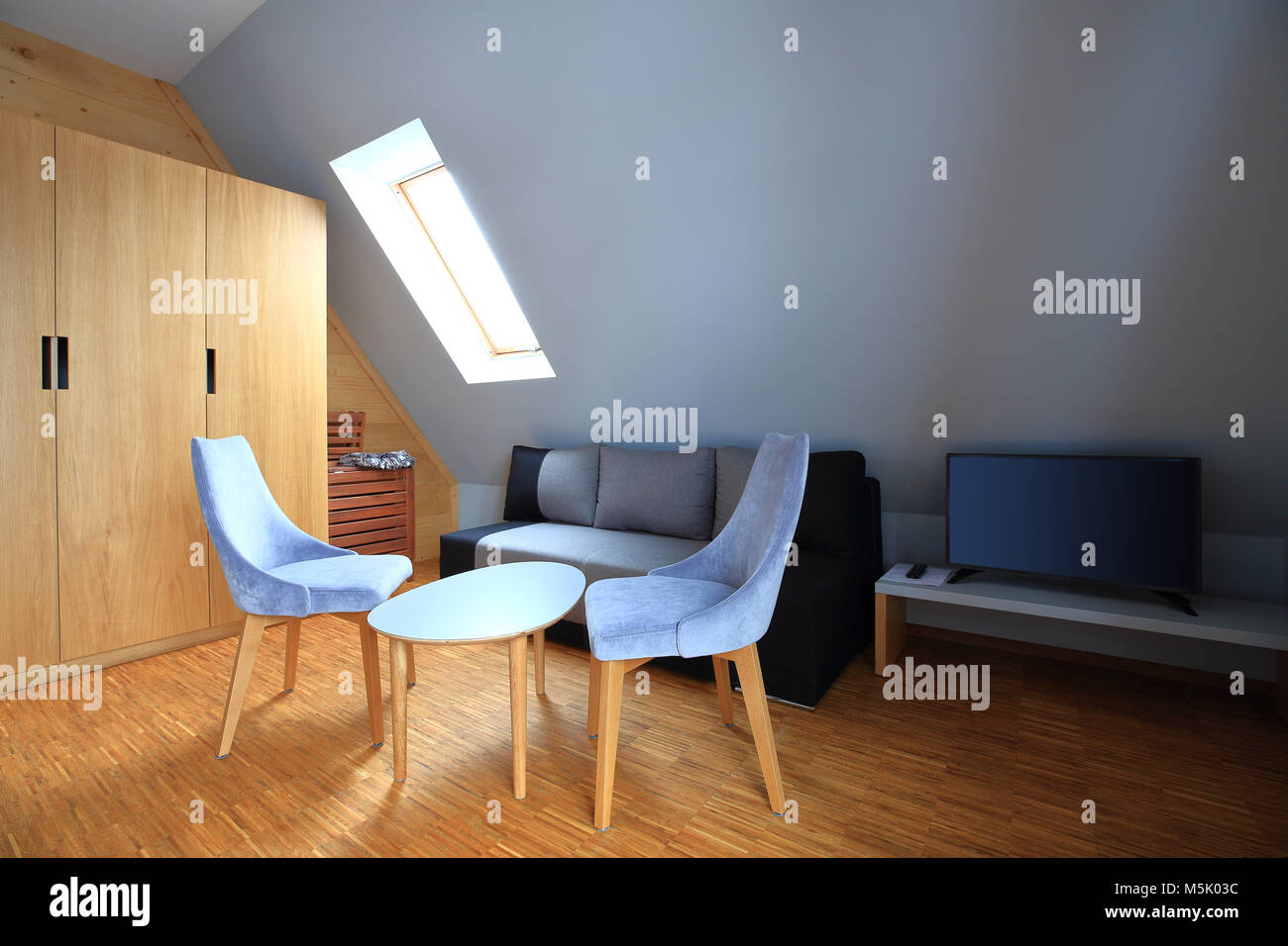 Сoffee tavolo con due sedie grigio su pavimento di legno. Moderni interni in legno. Foto Stock