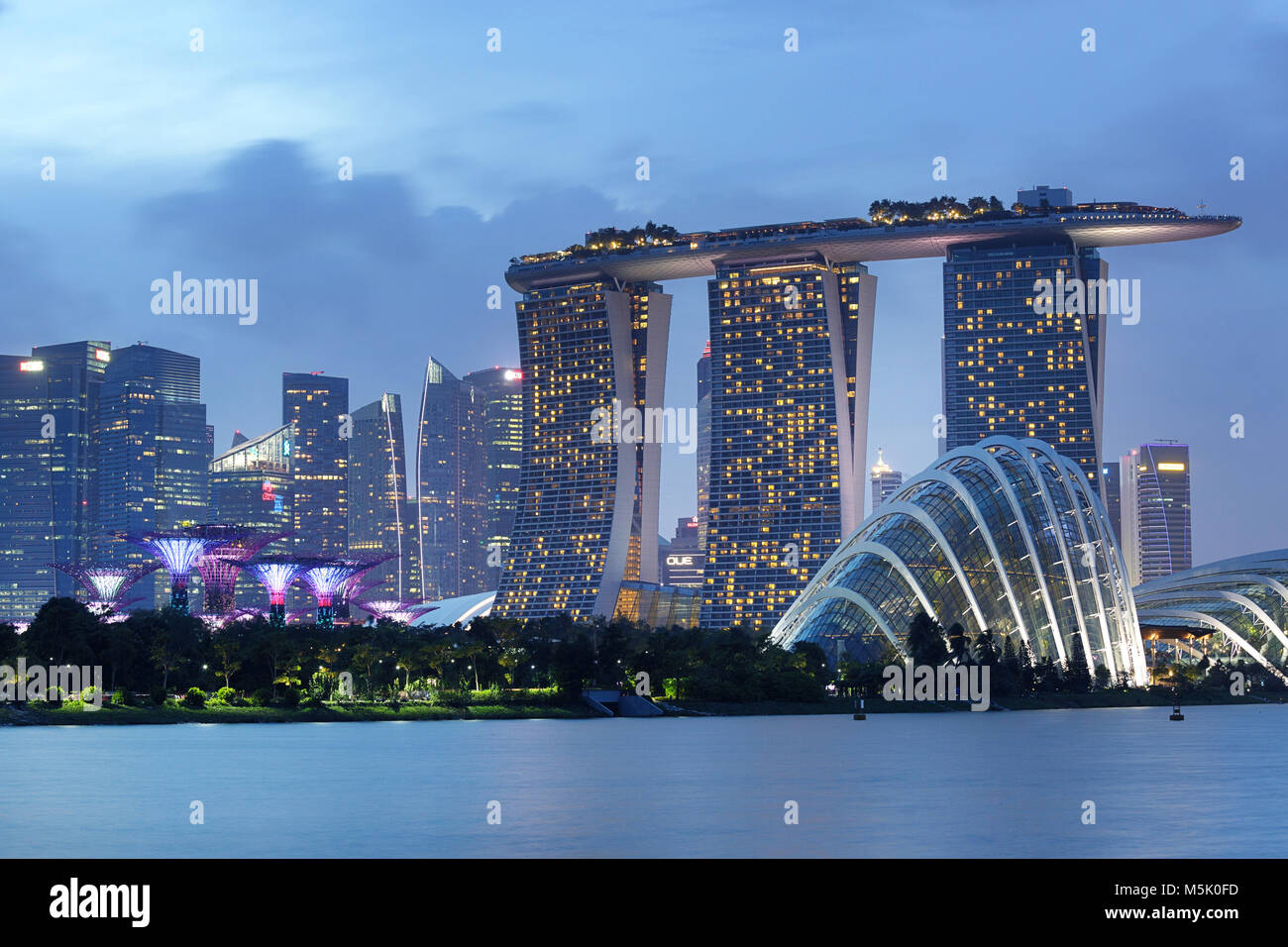 Lo skyline di Singapore presso il Marina Bay al crepuscolo con Supertrees, il Cloud Computing e le cupole di fiori, Marina Bay Sands Foto Stock