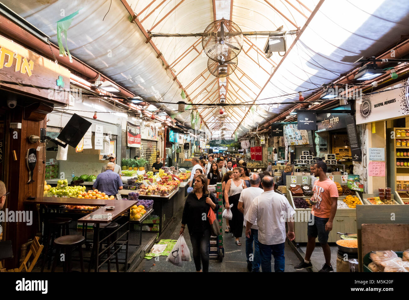 La gente a piedi a una delle strade della Mahane Yehuda Market a Gerusalemme. Foto Stock