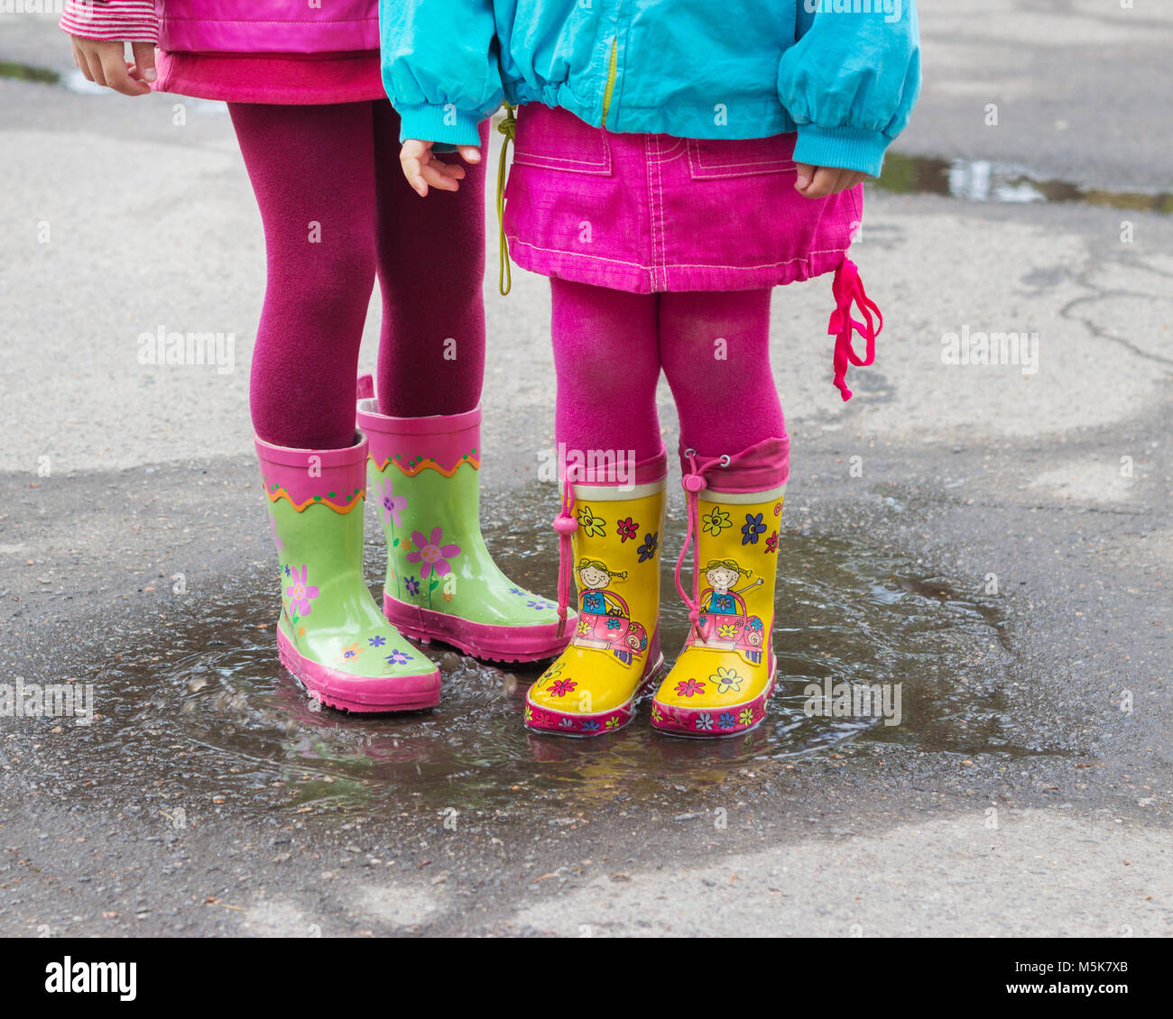 Bambini i piedi in stivali di gomma in una pozzanghera dopo la pioggia.  Messa a fuoco selettiva Foto stock - Alamy