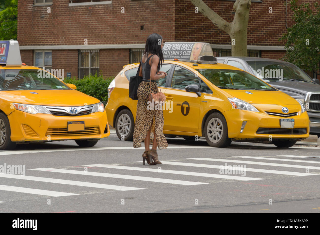 La città di New York, Stati Uniti d'America - Giugno 08, 2015: New York giallo taxi fermata a pedoni semaforo attraversare la strada in attraversamento pedonale. Foto Stock