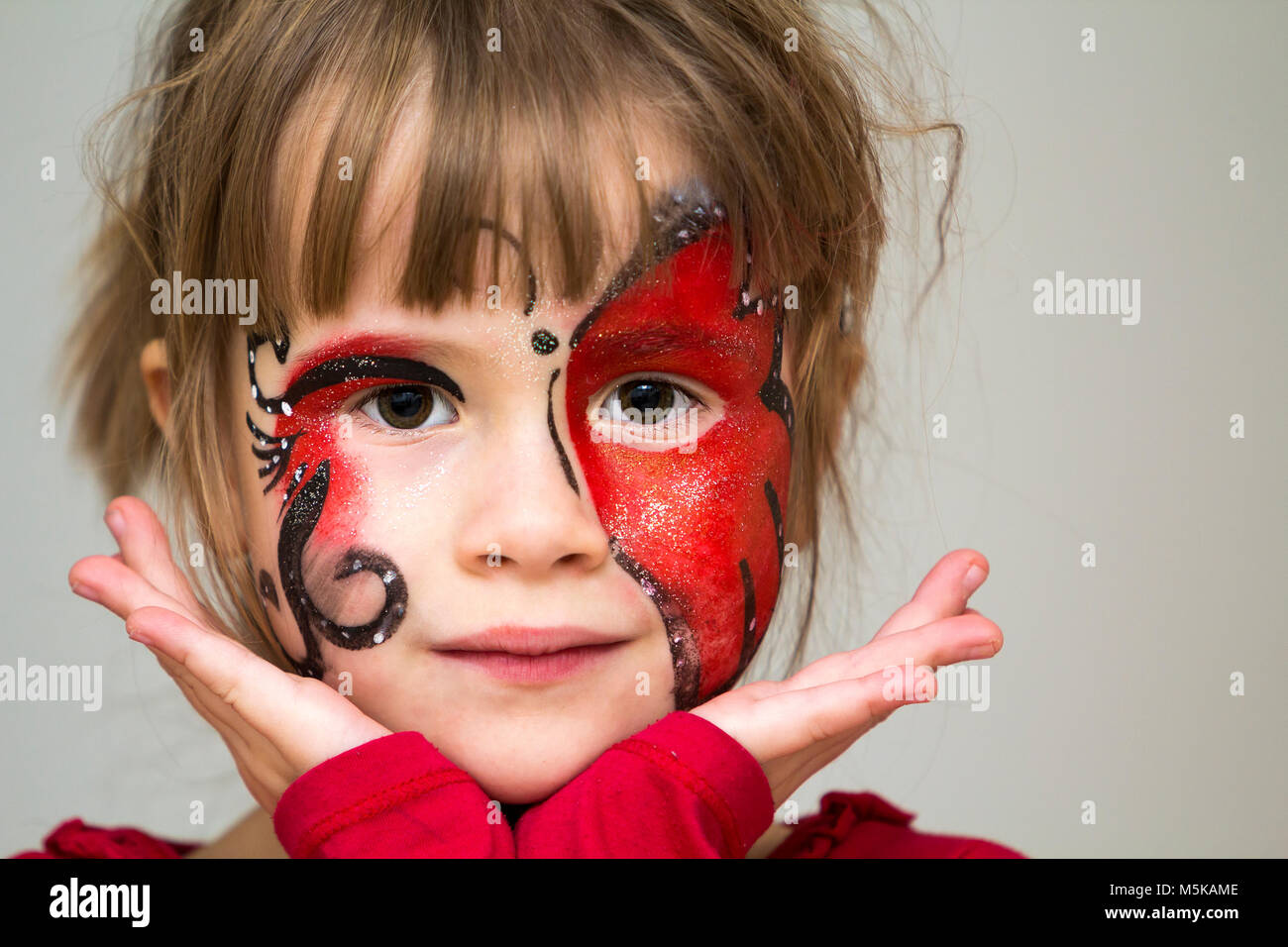 Ritratto di graziosa bambina con farfalla dipinto sul suo viso Foto Stock