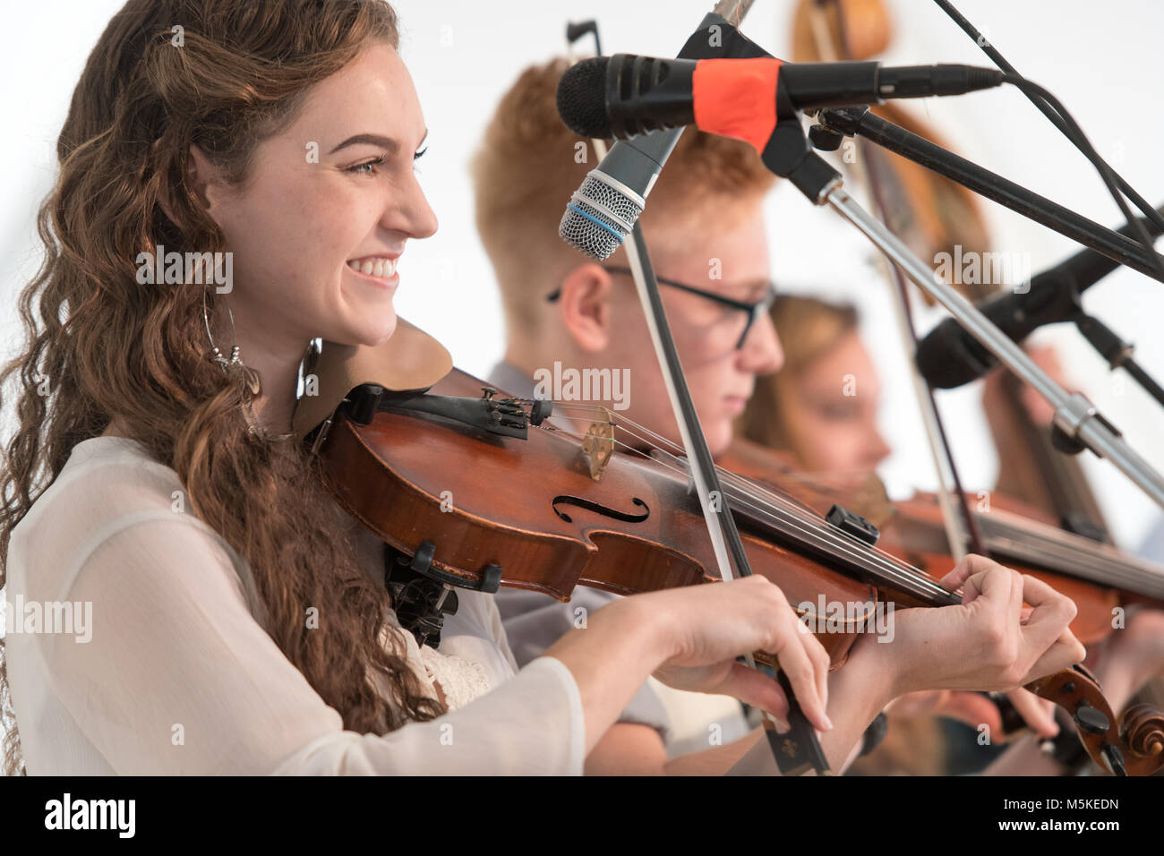 Giovani femmine dal gruppo musicale, rigorosamente di stringhe & Cole Cloggers montagna, sorrisi come ella archi sul suo violino, Greensboro, Nord Carolina. Foto Stock