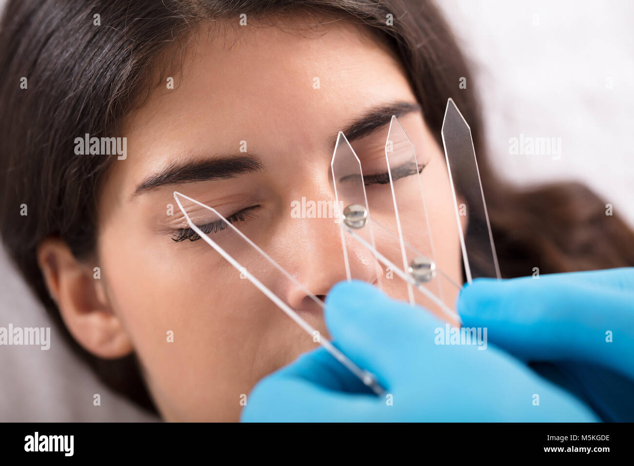 Cosmetologo misurando la simmetria di una donna e le sopracciglia con un attrezzo speciale Foto Stock