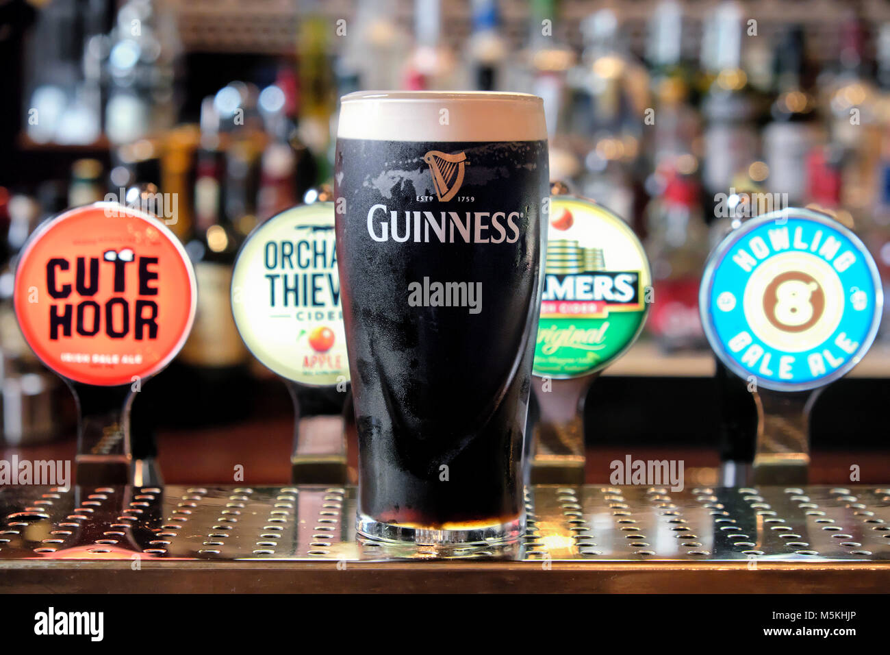 La pinta di Guinness davanti a differenti ale e birra pompe, il Merchant's Arch Bar & Ristorante, Temple Bar di Dublino, Irlanda Foto Stock