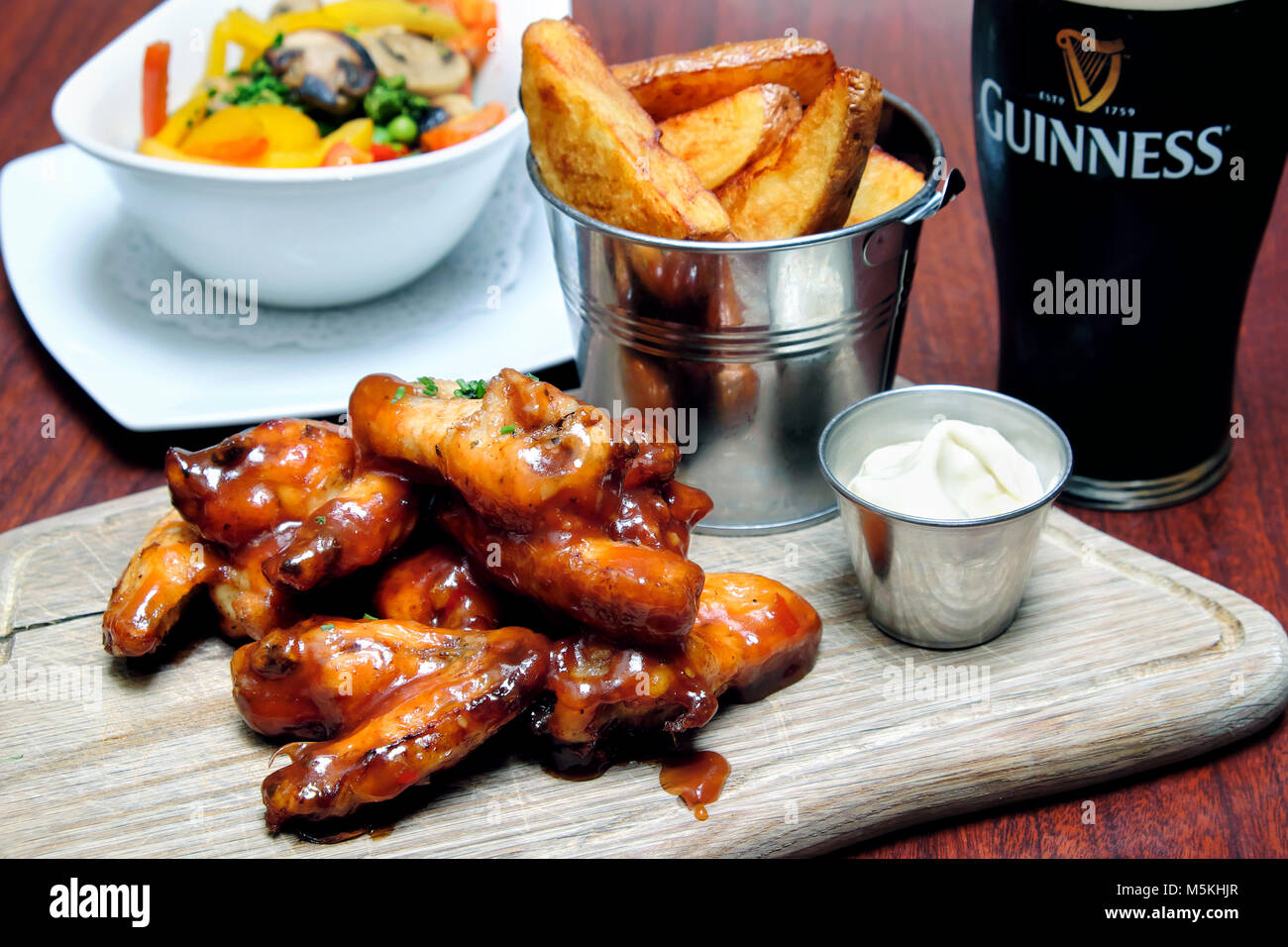 Ali di pollo si lancia in un barbecue e salsa al peperoncino dolce servito con il formaggio blu dip, chip e una pinta di Guinness, Doheny & Nesbitt Pub di Dublino, Irlanda Foto Stock Ali di pollo si lancia in un barbecue e salsa al peperoncino dolce servito con il formaggio blu dip, chip e una pinta di Guinness, Doheny & Nesbitt Pub di Dublino, Irlanda Foto Stock