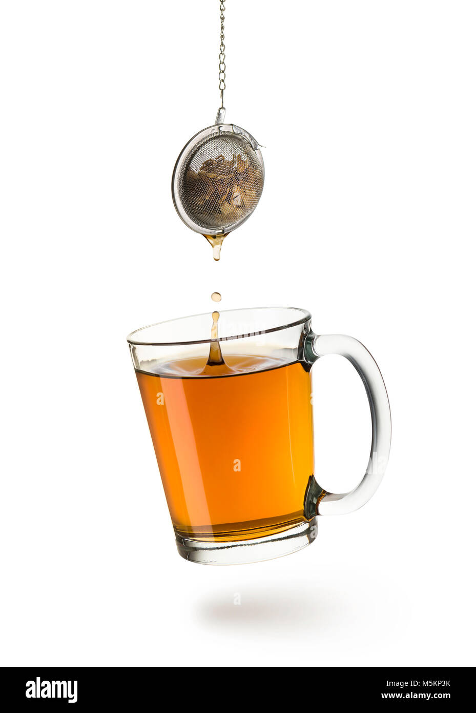 Bicchiere di vetro pieno di tè Il tè con infusore caduta, su sfondo bianco Foto Stock