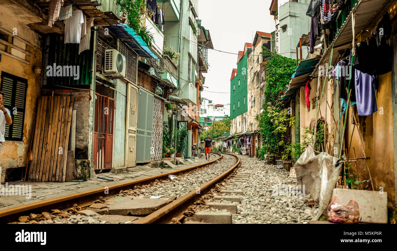 Un binario ferroviario passa attraverso le case e negozi di una strada ad Hanoi, Vietnam Foto Stock