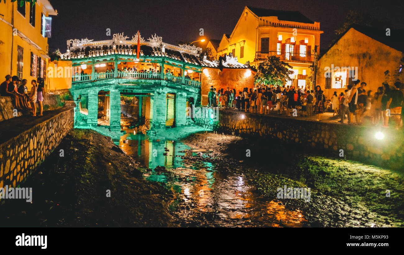 I turisti a piedi attraverso Hoi An Old Town di notte con tutto il colorato lanterne accese fino in Vietnam Foto Stock