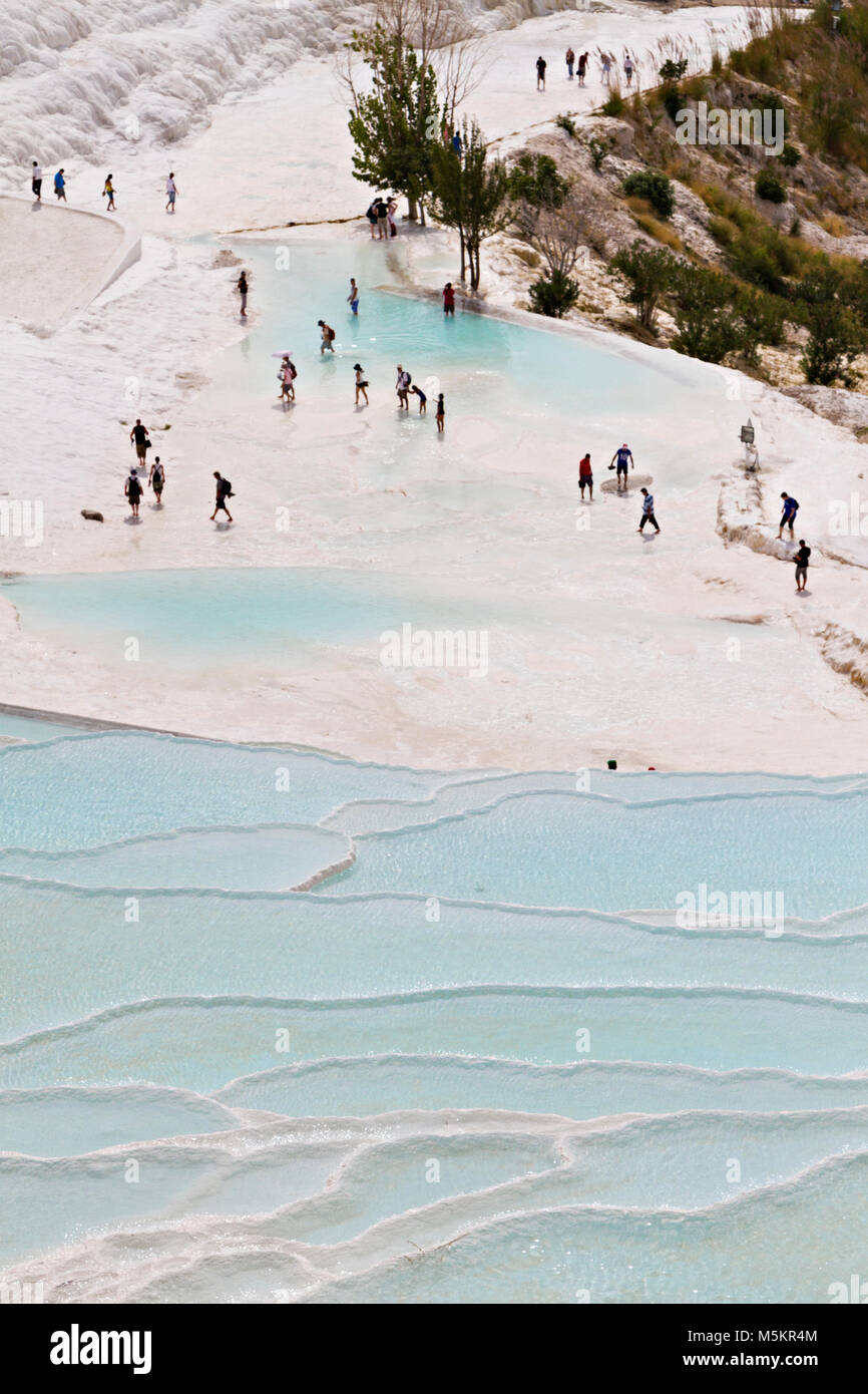 I turisti a piedi in terrazze di travertino riempito con acqua, in Pamukkale, Turchia. Foto Stock