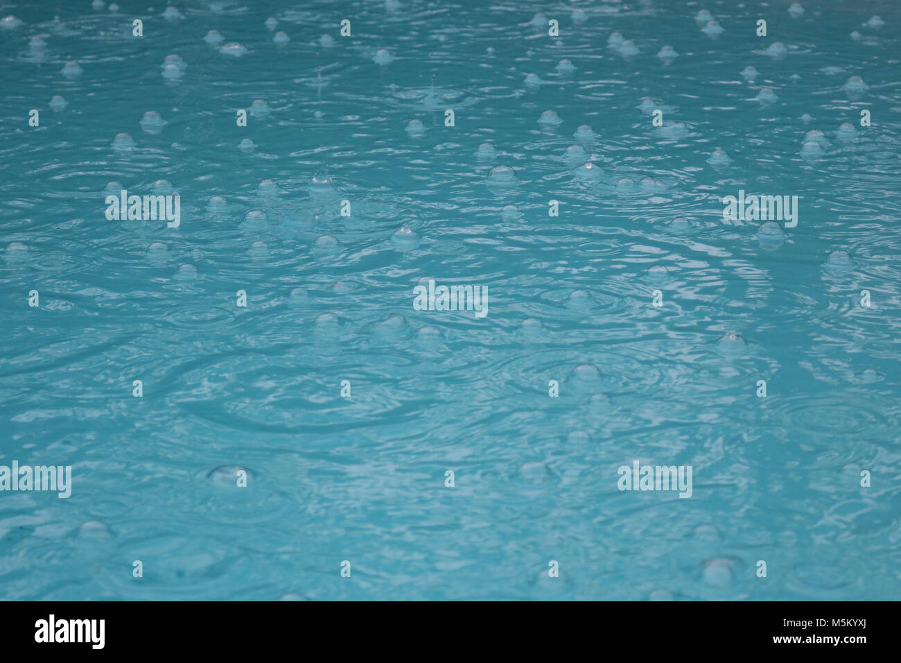 Superficie della piscina in tempesta di pioggia Foto Stock