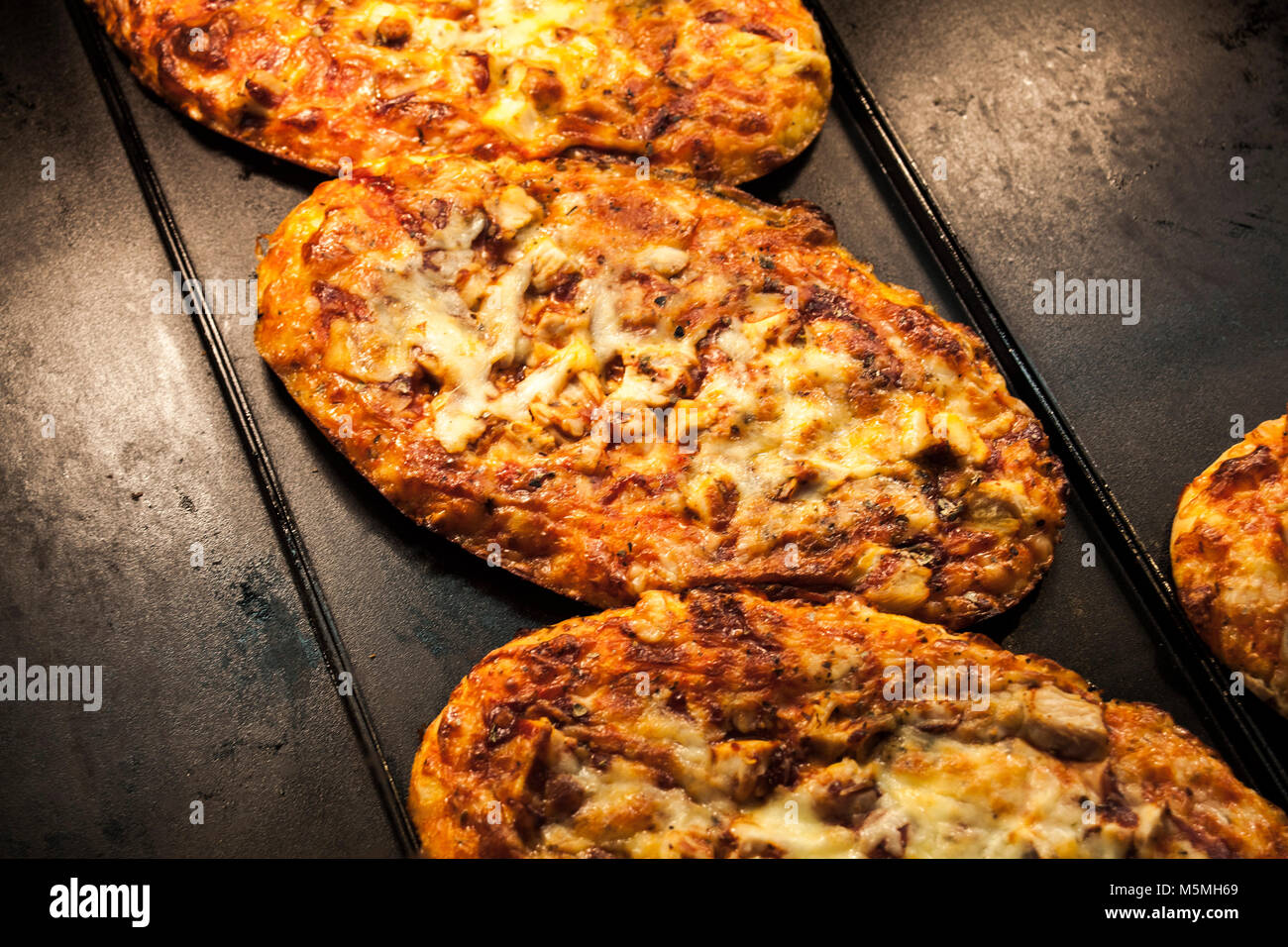 Mini pizza con salame, formaggio e pomodoro, deliciues, mini pizza. Foto Stock