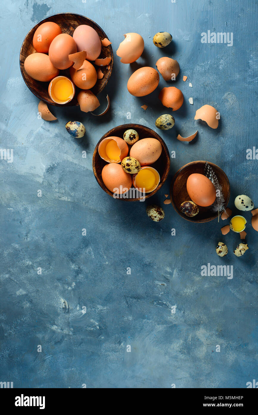 Assortimento di uova crude in piatti di legno. Moderno concetto di Pasqua con copia spazio. Vista da sopra. Foto Stock