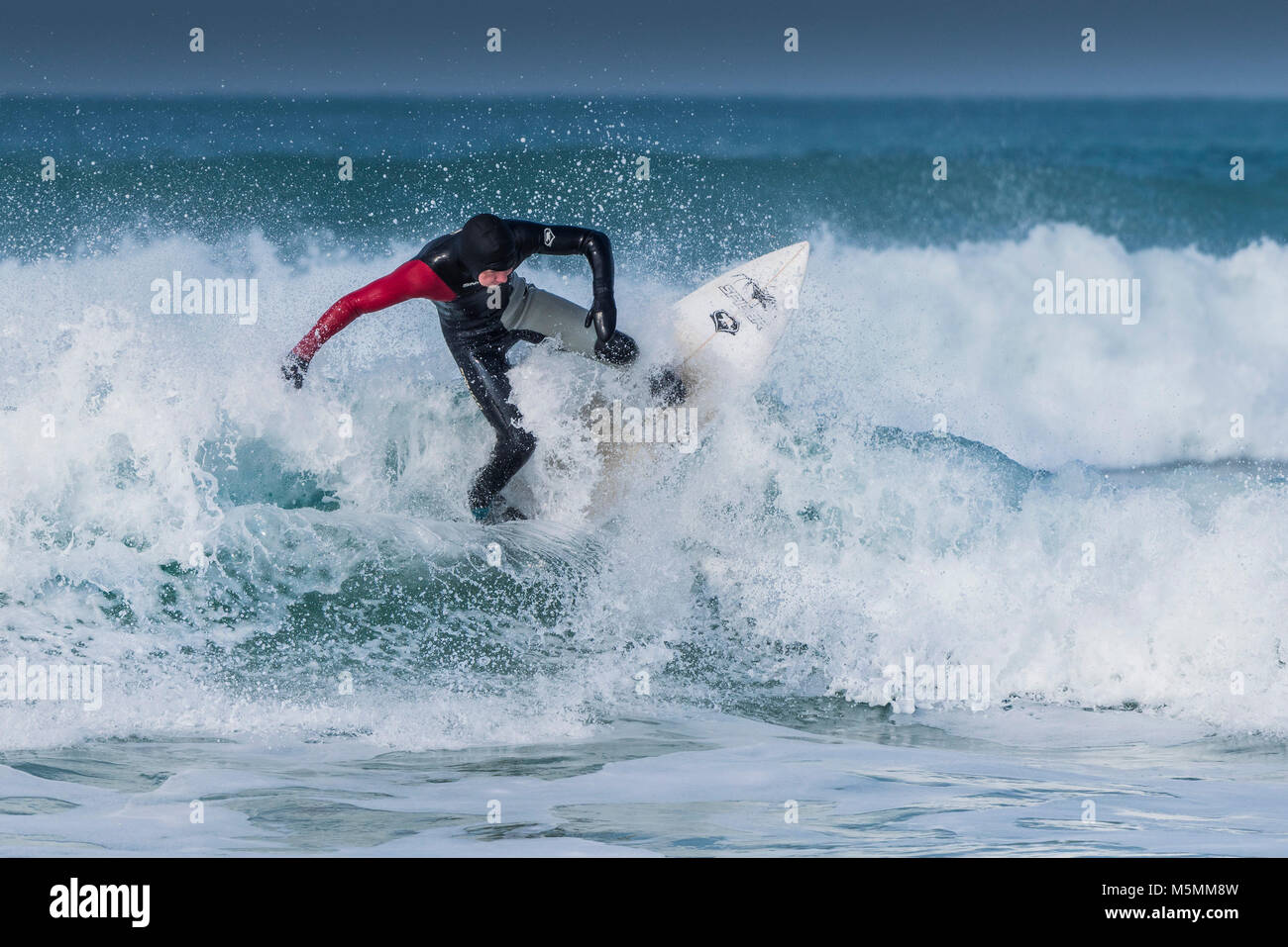 Un surfista a cavallo di un onda al Fistral in Newquay, Cornwall. Foto Stock