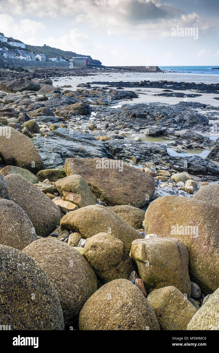 Rocce esposte a bassa marea in Sennen Cove in Cornovaglia. Foto Stock