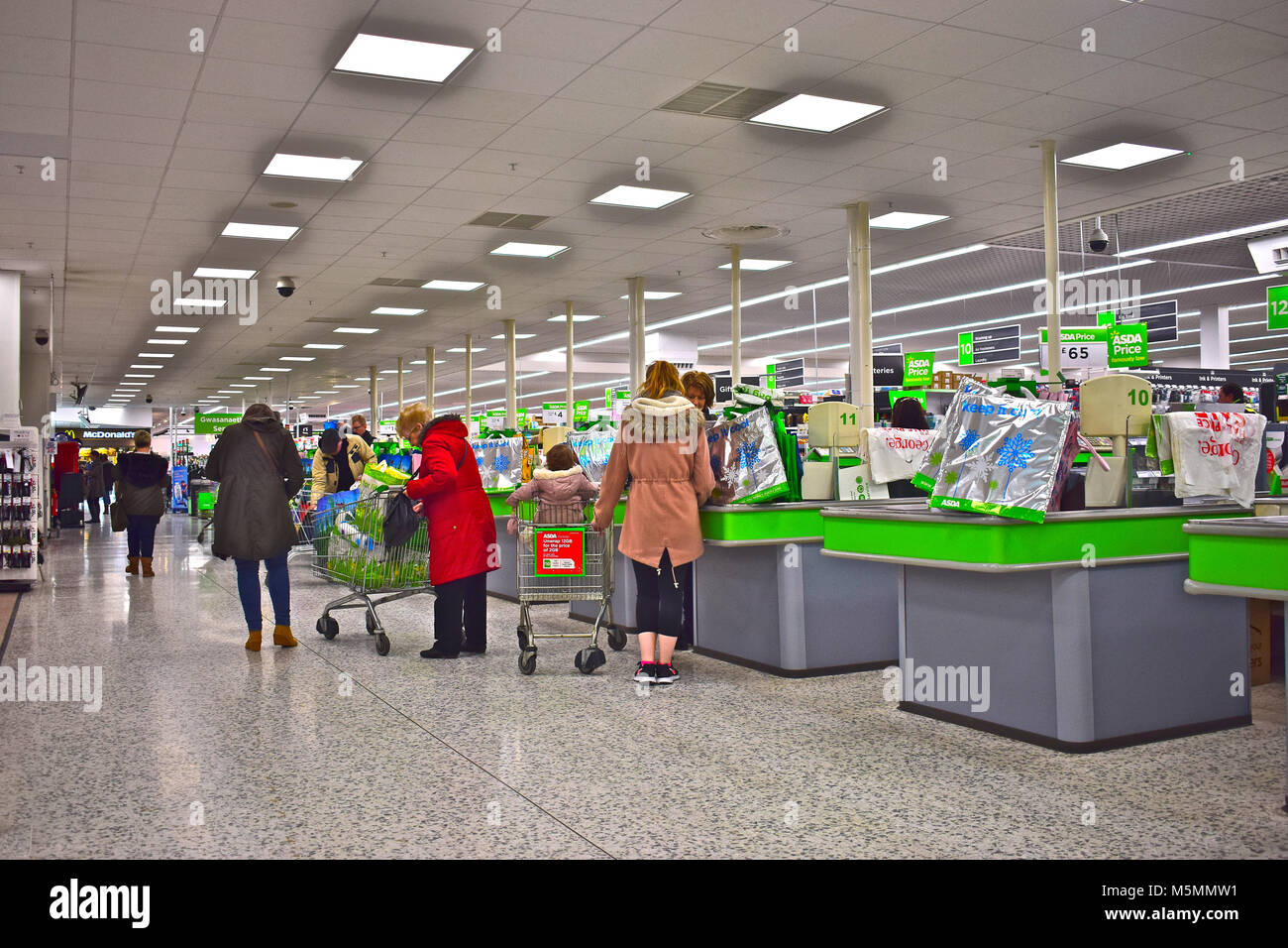 Gli acquirenti di lasciare le casse al moderno supermercato Asda in Dyffryn, Newport, se il Galles. Foto Stock
