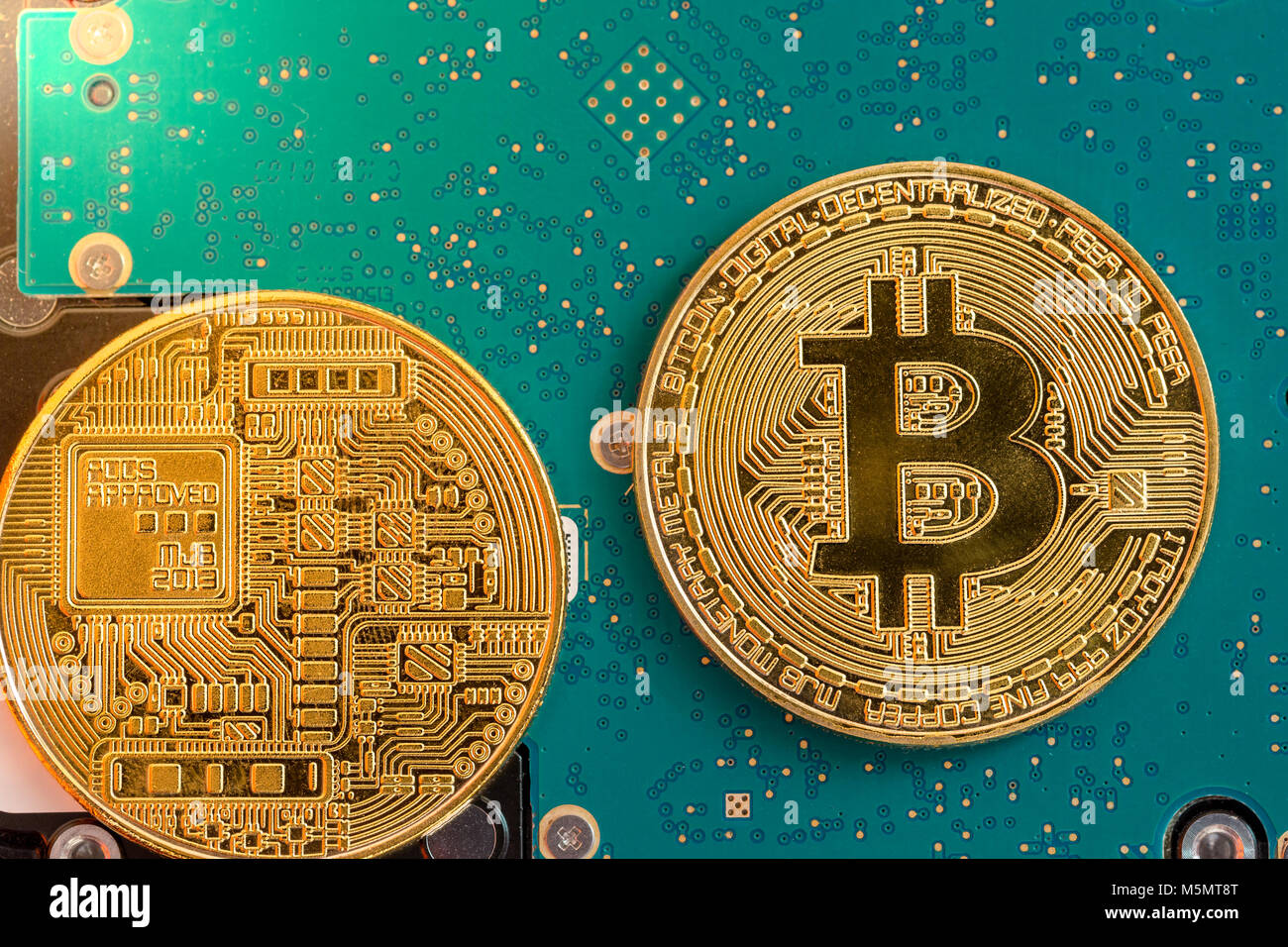 Due lati del golden bitcoin su hard disk electronics Foto Stock