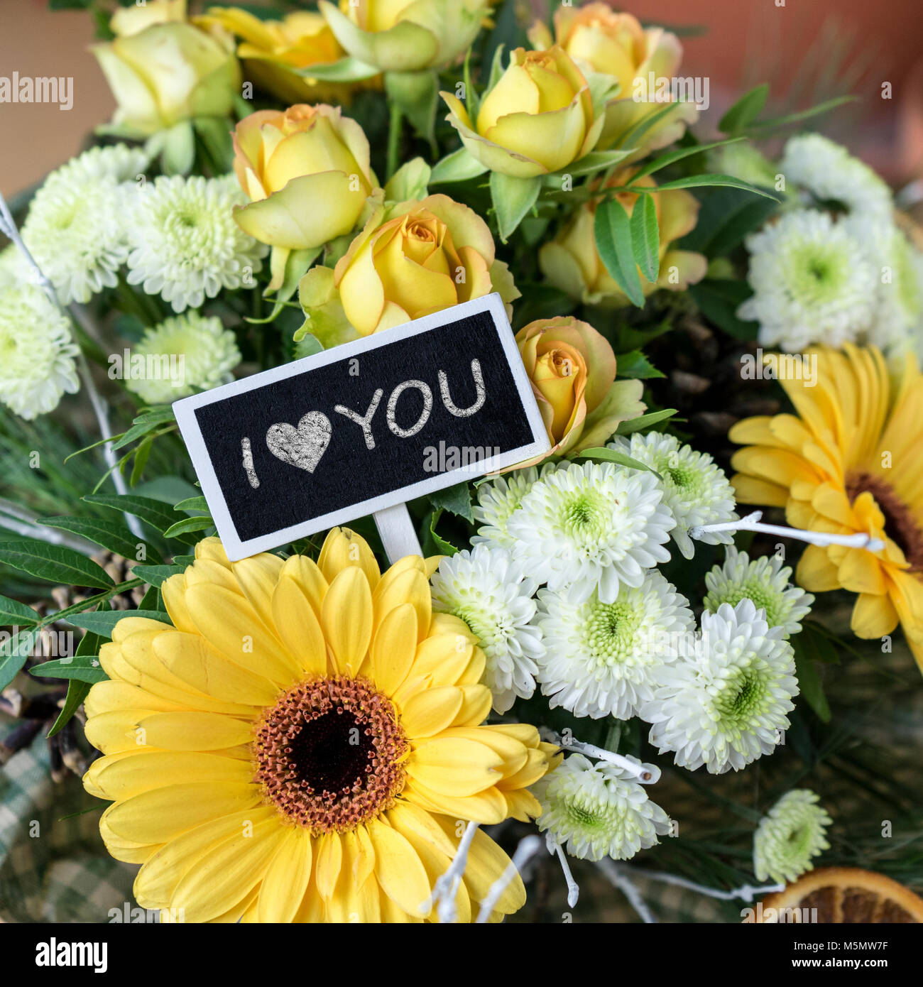 Bouquet di giallo e bianco rose e gerbere, crisantemi e una piccola lavagna con testo: ti amo Foto Stock