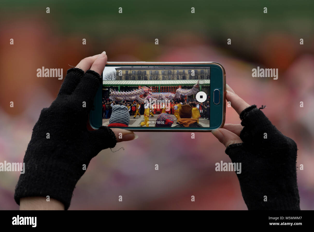 Mani con guanti corti che tengono uno smartphone mentre fotografa Foto Stock