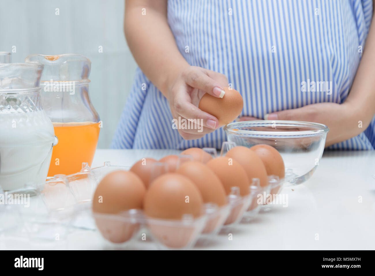 Donna incinta la preparazione di pasto al tavolo in cucina,sana nutrizione durante la gravidanza Foto Stock