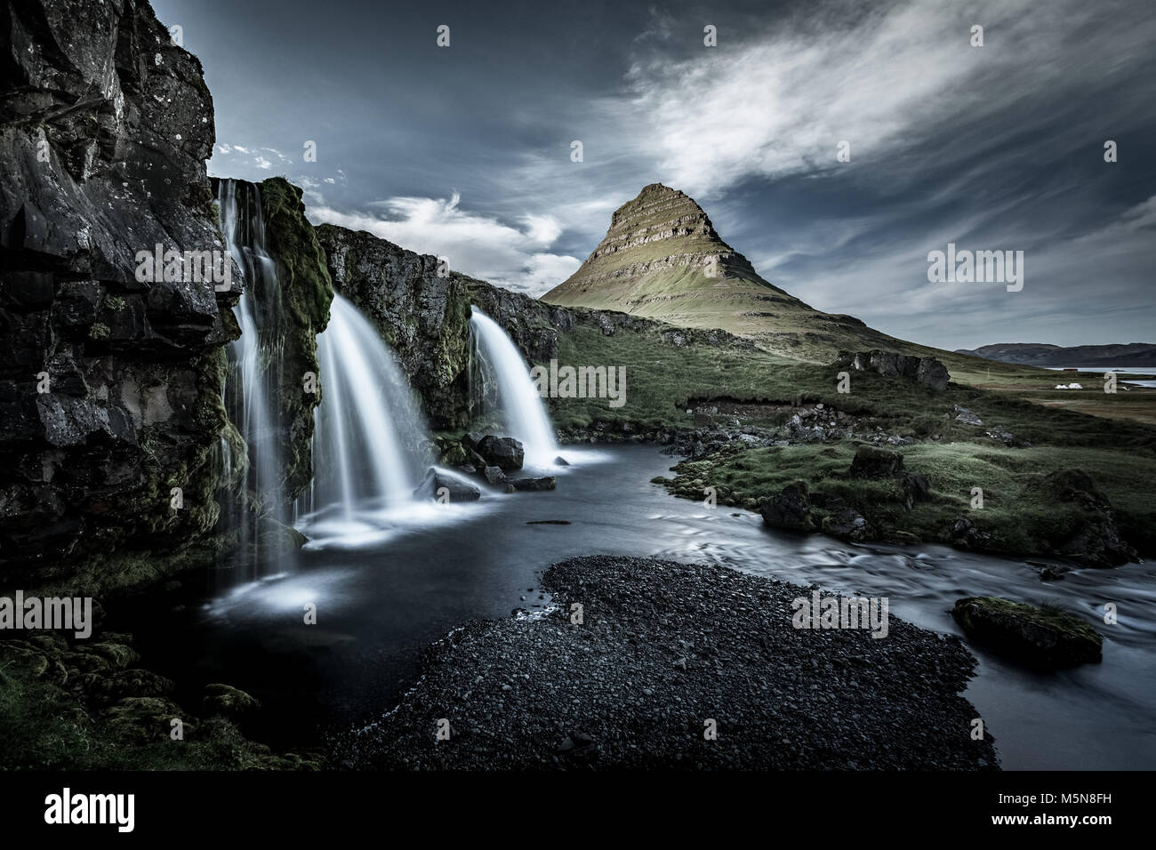 Kirkjufell montagna, Snaefellsnes peninsula, Islanda. Paesaggio con cascate, esposizione a lungo in una giornata di sole Foto Stock