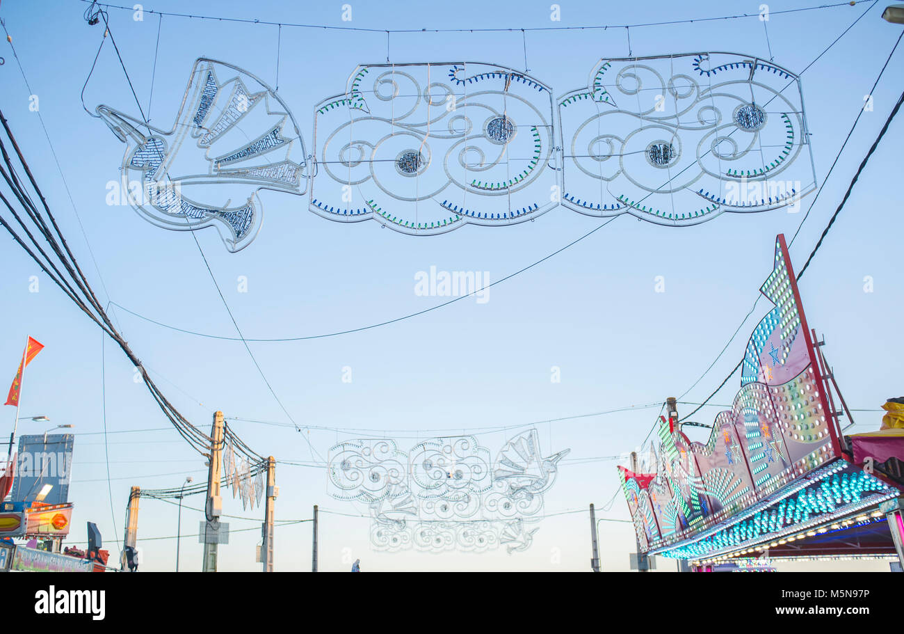 Fiera cielo pieno di decorazioni pensili, lampadine, fili elettrici e poli. Colpo di luce diurna Foto Stock