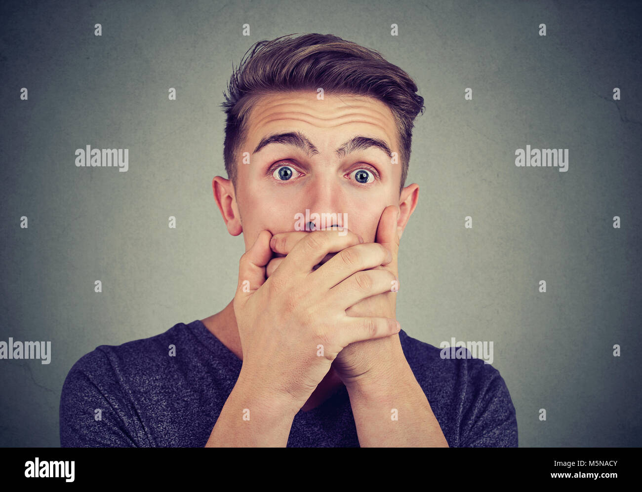 Ritratto di un giovane uomo ansioso con scioccato spaventato di fronte alla ricerca di espressione in telecamera Foto Stock