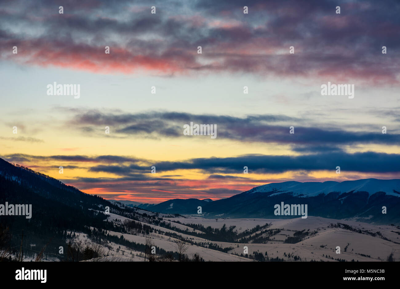 Bellissime le nuvole colorate sopra la montagna cresta. bellissimo cielo all'alba d'inverno Foto Stock