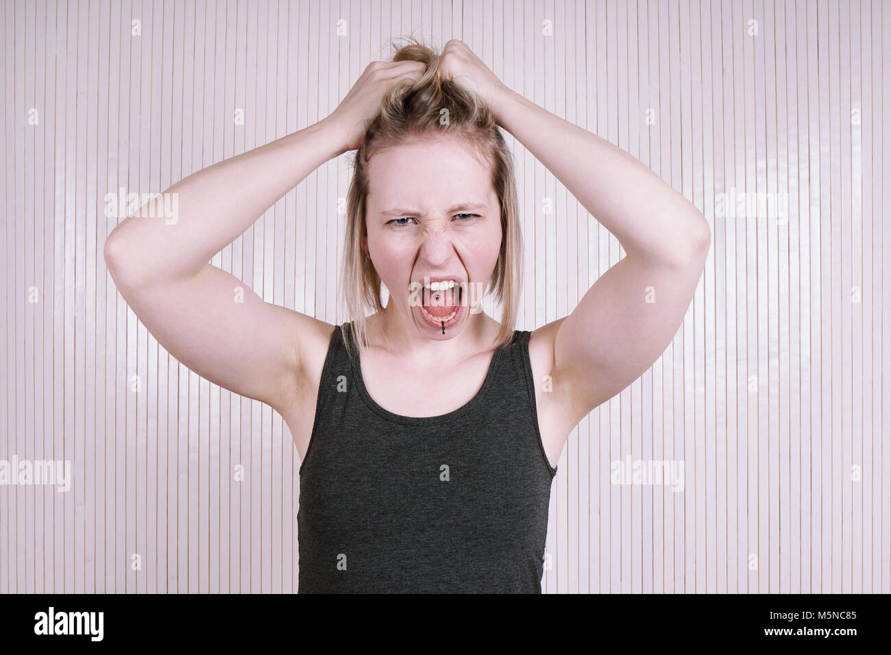 Indignato giovane donna avente una temper tantrum gridando e urlando Foto Stock